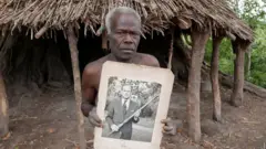 Village elder from Tanna island hold a picture of Britain Prince Philip wia dem dey worship in Yaohnanen, Vanuatu 6 May 2017
