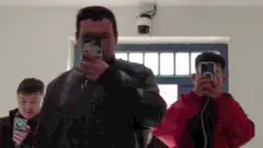 muškarci drže telefone i snimaju 