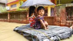నీరు చుట్టుముట్టిన ఇళ్ల నుంచి చిన్నారులను పునరావాస కేంద్రాలకు తరలిస్తున్నారు