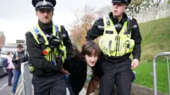 Police detain a protester in York