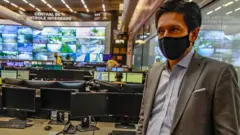 Ricardo Nunes de máscara em centro de monitoramento, repleto de telas
