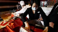 北京市一家餐館服務人員正在為客人打包外賣年夜飯