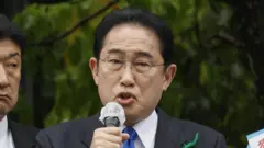 Fumio Kishidia holding a microphone