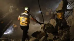 Members of the Syrian Civil Defence (White Helmets) search for survivors following a reported airstrike by Syrian regime forces in Maaret al-Numan in Syria's northwestern Idlib province