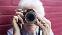 Пожилая женщина с камерой Olympus