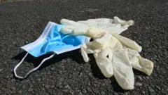Sokağa atılmış plastik eldiven ve maske.