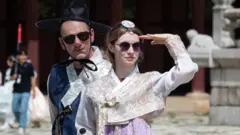 사상 첫 폭염 대응 중앙재난안전대책본부 2단계가 발령된 가운데 4일 서울 경복궁을 찾은 외국인 관광객들이 한복을 입고 궁을 둘러보고 있다