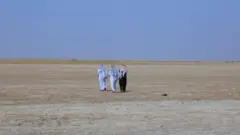 أشخاص يسيرون فوق بحيرة ساوة التي باتت أرضا جدباء