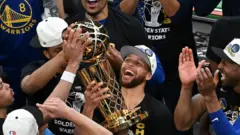 Stephen Curry lifts the NBA trophy in 2022