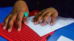 Donatile Kanimba, avugira abafite ubumuga bwo kutabona mu Rwanda. Yandika akoresheje uburyo bwa braille