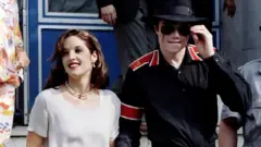 Pop star Michael Jackson and his bride Lisa Marie Presley-Jackson hold each others hands outside Heim Pal Children's Hospital where they distributed toys in Budapest, Hungary August 6, 1994