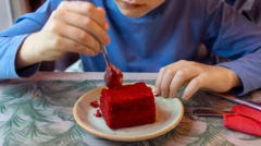 Kırmızı bir kek yiyen çocuk