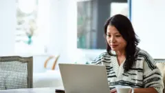 إمرأة تعمل على حاسوبها المحمول