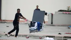 Pesin wey dey push cart with Tv inside
