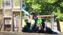 Two police officers comfort each other at the scene
