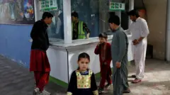 A little girl stands in front of a ticket booth in an amusement park in Kabul, Afghanistan, November 9, 2022.