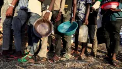 የእርዳታ እህል ለመቀበል የተሰለፉ ሰዎች
