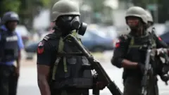 Nigeria police cari gun wia tear gas mask