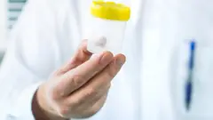 Doctor holding a clear container