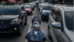 Garoto indonésio com pele pintada de prata anda entre carros em uma rodovia congestionada