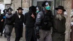 Policías detienen a hombres ultraortodoxos.