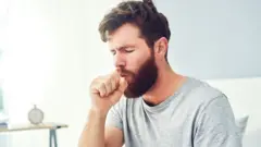A man coughing