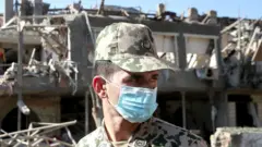 азербайджанский солдат-срочник, Гянджа, развалины