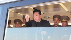 North Korea's leader Kim Jong-un points as he watches the test-fire of a new type of nuclear weapon at an undisclosed location on 17 April