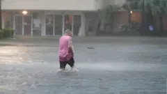 በአልባማ በጎርፍ መካከል የሚሄድ ሰው
