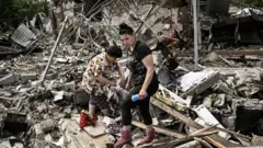Residents look for belongings in the rubble of their home after a strike in the eastern Ukrainian region of Donbas, 1 June 2022