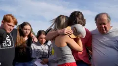 People console each other at a vigil after the shooting.