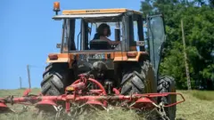 femal works on her tractor