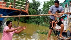 వరదలో చిక్కుకున్న ప్రజలను సురక్షిత ప్రాంతాలకు తరలిస్తున్న ఆంధ్రప్రదేశ్ ఫైర్ సర్వీసు సిబ్బంది