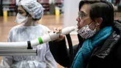 করোনাভাইরাস শনাক্তের জন্য ফ্রান্সে এক ব্যক্তি 'ব্রেদালাইজার টেস্ট' ব্যবহার করছে।