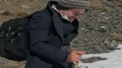 Kameel Ahmady walks through mountains while escaping Iran