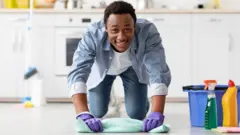 Un homme souriant fait le ménage