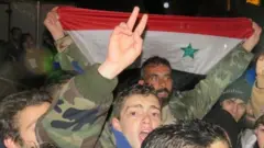 アレッポの政府掌握地域で政府軍の進攻を祝う人々(12日)