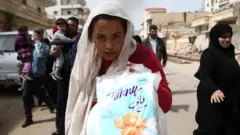 فتاة وعائلتها تفر من عفرين بعد أن هاجم الجيش التركي عليها إلى جانب الفصائل المعارضة المسلحة.