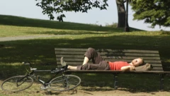 Homem dormindo em banco de praça