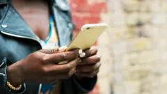 una mujer sostiene un celular