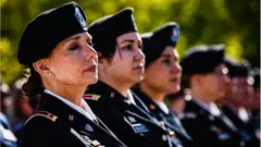 Chief Warrant Officer Four, Rosemary Masters, of Oklahoma Army National Guard, left, listens to the speaker during the 20th Anniversary of Women In Military Service For America Memorial celebration on Saturday, October 21, 2017, at the Arlington National Cemetery in Arlington, VA.