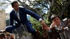Juan Guaidó trepa una verja.
