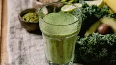 Surtido de alimentos estacionales, incluyendo col rizada, espirulina y aguacate