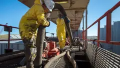 Hombre rellena un tanque de petróleo
