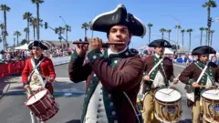 Hombres vestidos como collonos revolucionarios en un desfile del 4 de julio en Estados Unidos