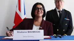 شبانه محمود قلم په لاس خندانه حالت کې