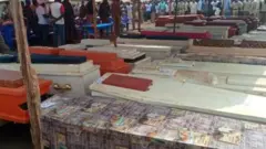 Mourners line up before di coffins to pay dia respects for di funeral on Friday