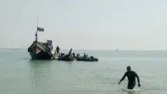 স্থানীয় ট্রলারের সহায়তায় নিমজ্জিত ট্রলারটিকে টেনে সোজা করা হচ্ছে।