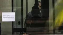 Jair Bolsonaro por trás da porta de vidro da Superintendência da Polícia Federal de Brasília neste domingo.