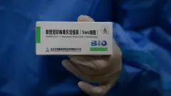 বেইজিংয়ে সিনোফার্ফের টিকা দেখাচ্ছেন একজন স্বাস্থ্যকর্মী